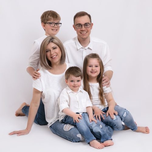 studio portrait family session of 5. They are all wearing a white t-shirt and jeans.