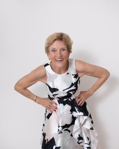 Studio headshot woman wearing white elegant dress with black flowers